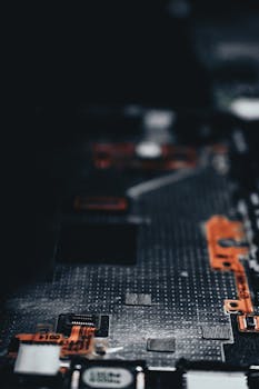 Close-up of a dark circuit board showcasing electronic components and connections.